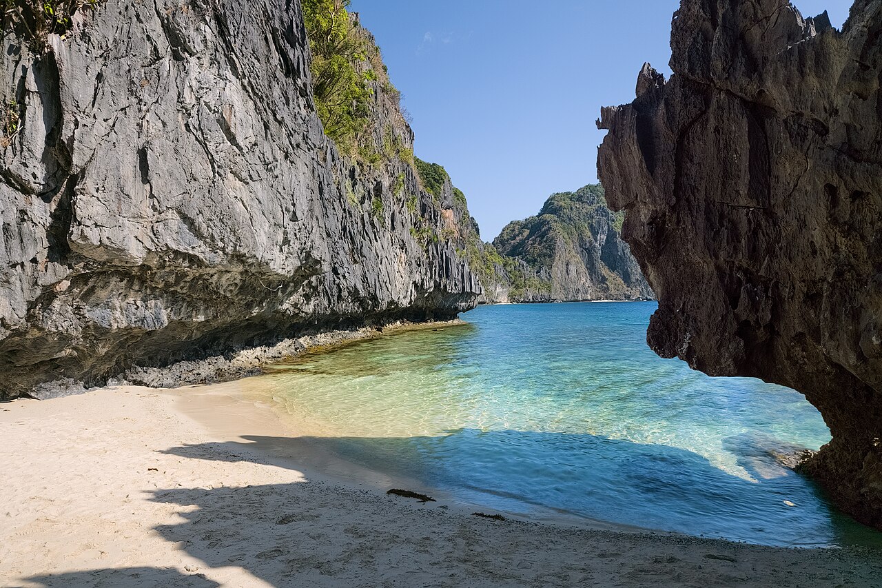 Playa escondida entre acantilados de caliza en la isla de Matinloc, El Nido